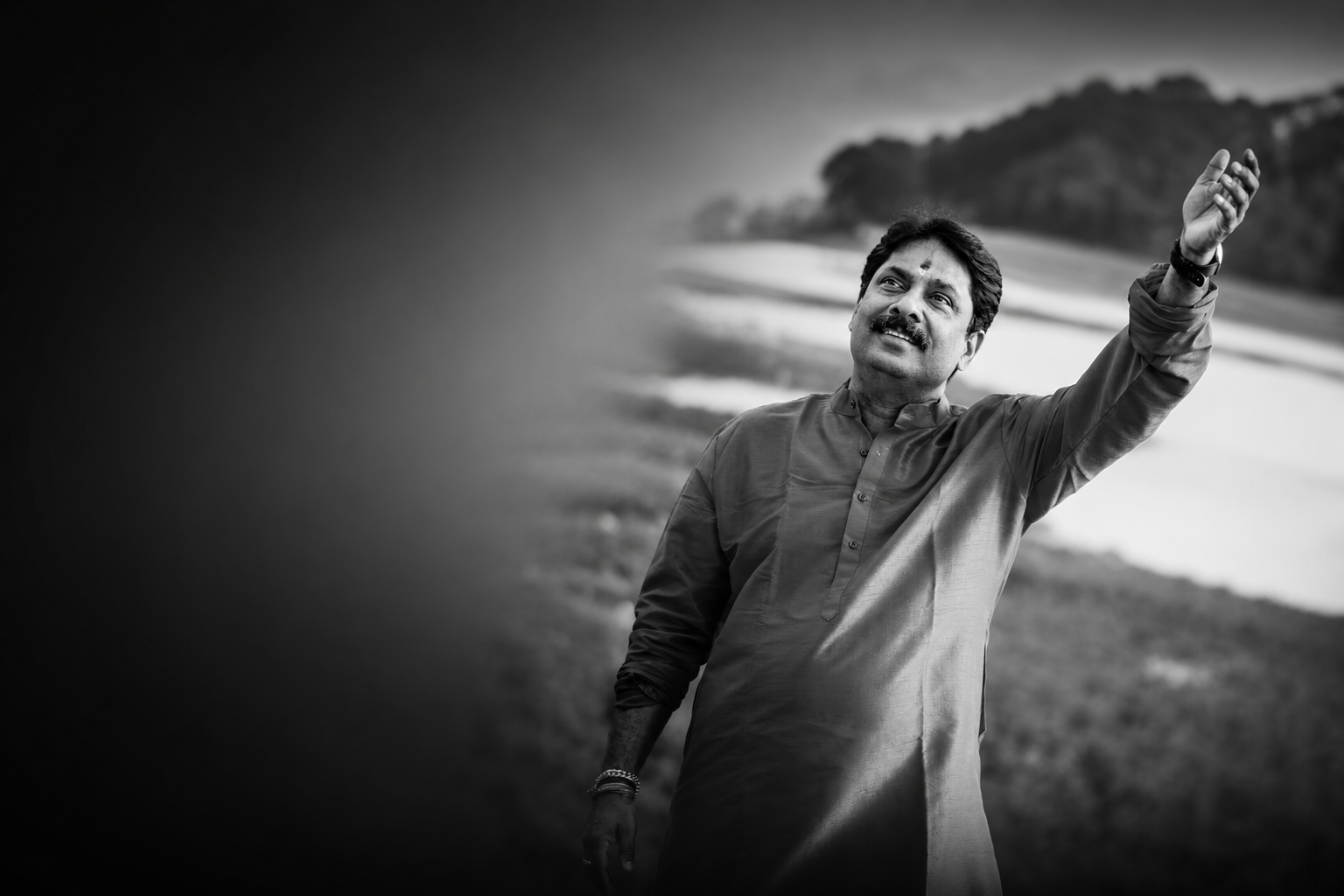 Sivaprasad NN standing beside a quiet waterside landscape